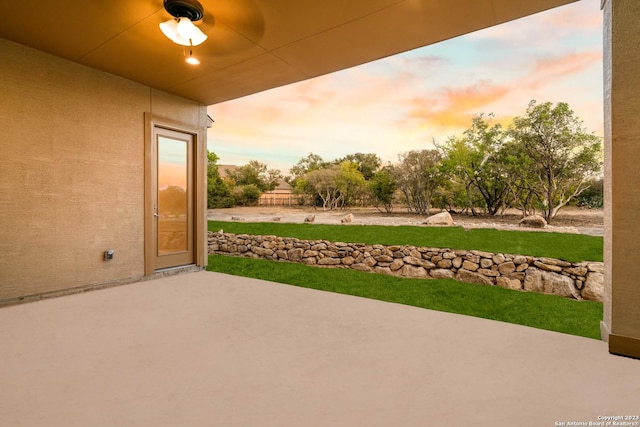 patio terrace at dusk featuring ceiling fan