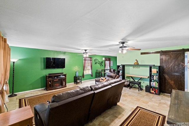 living room with ceiling fan and a barn door