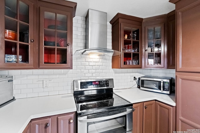 kitchen with appliances with stainless steel finishes, decorative backsplash, and wall chimney range hood