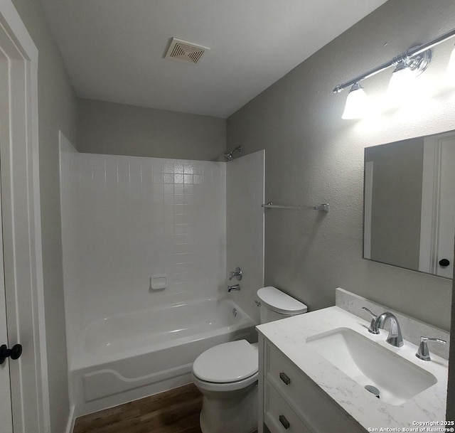 full bathroom featuring hardwood / wood-style flooring, vanity, bathtub / shower combination, and toilet