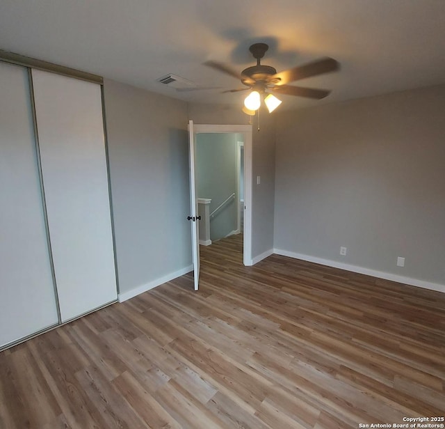 unfurnished bedroom featuring light hardwood / wood-style flooring, a closet, and ceiling fan