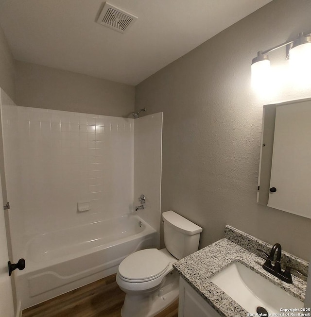 full bathroom with hardwood / wood-style flooring, toilet, vanity, and shower / bathing tub combination