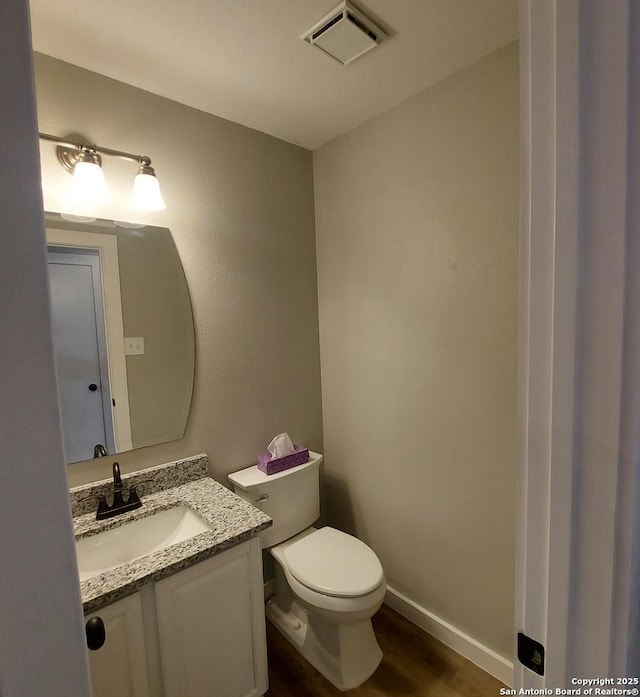 bathroom featuring hardwood / wood-style flooring, vanity, and toilet