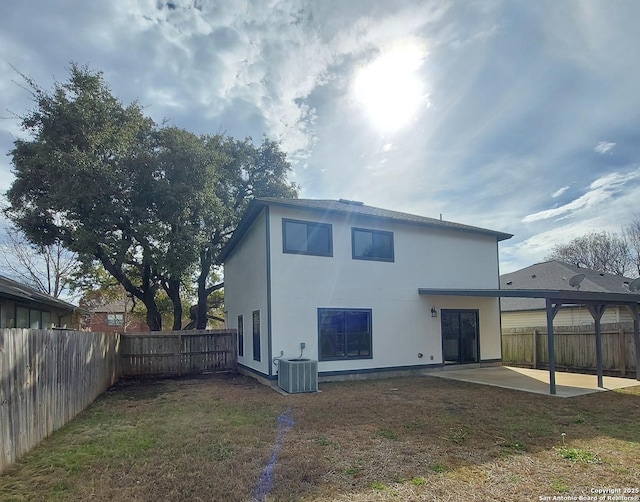 rear view of property featuring cooling unit, a yard, and a patio area