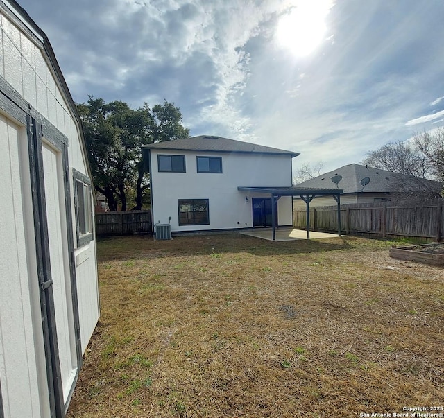 back of house with a yard, central AC unit, and a patio area