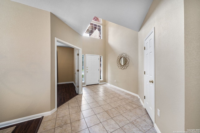 entrance foyer featuring light tile patterned floors and a towering ceiling