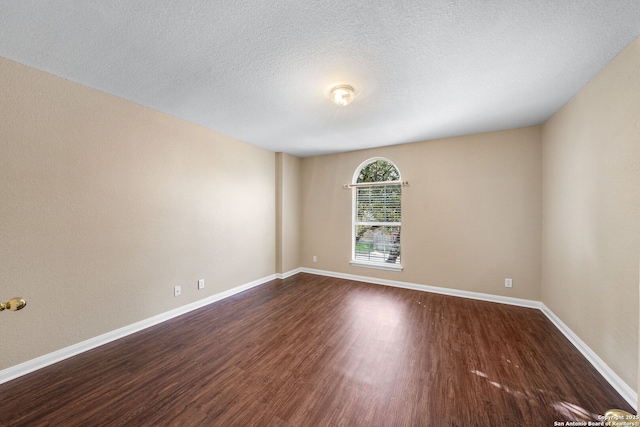 spare room featuring hardwood / wood-style flooring and a textured ceiling