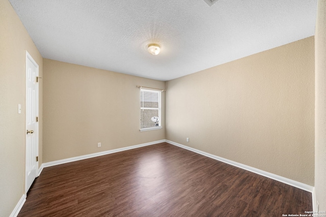 empty room featuring dark hardwood / wood-style flooring and a textured ceiling