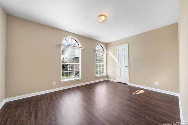 spare room featuring dark wood-type flooring