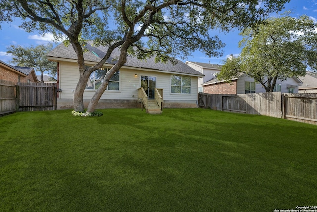 rear view of property featuring a yard