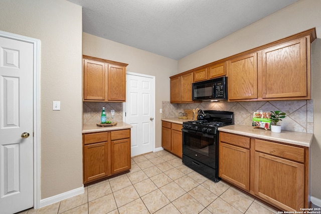 kitchen with light tile patterned flooring, a textured ceiling, black appliances, and backsplash