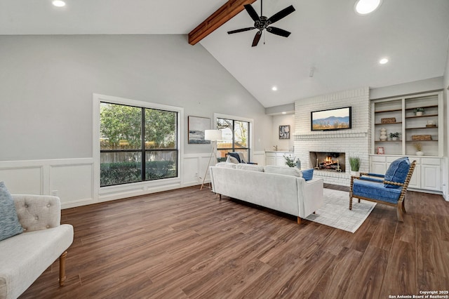 living room featuring dark hardwood / wood-style floors, a fireplace, beam ceiling, and high vaulted ceiling