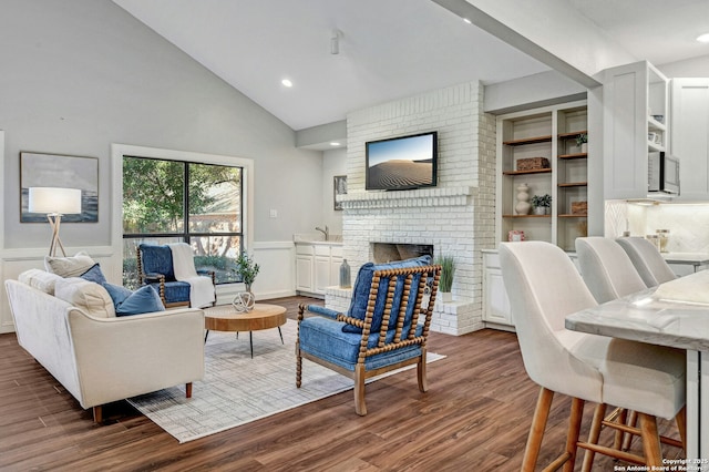 living room with dark hardwood / wood-style flooring, a brick fireplace, and high vaulted ceiling