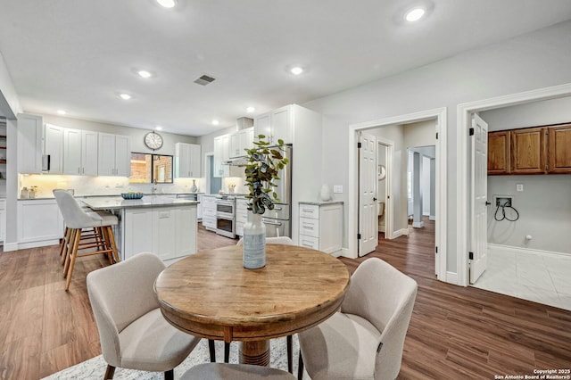 dining space featuring wood-type flooring and sink