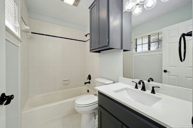 full bathroom featuring vanity, tiled shower / bath combo, tile patterned floors, and toilet