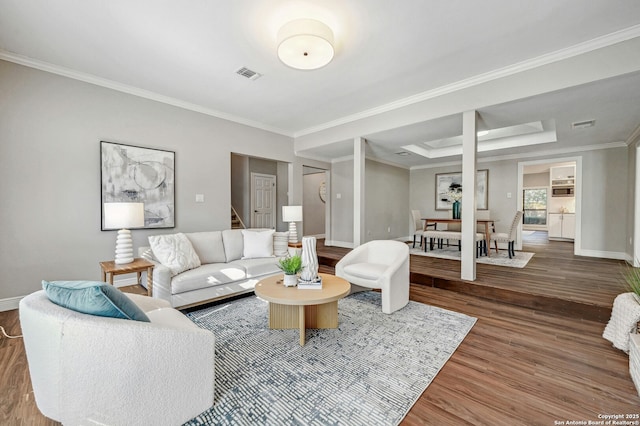 living room featuring hardwood / wood-style floors, a tray ceiling, and ornamental molding