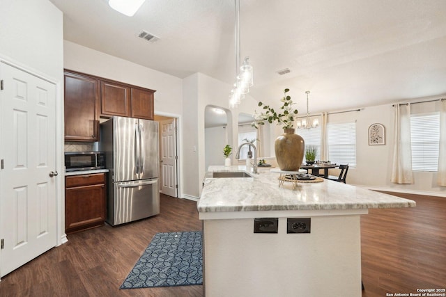 kitchen featuring appliances with stainless steel finishes, tasteful backsplash, sink, dark hardwood / wood-style flooring, and hanging light fixtures