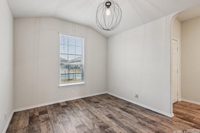 unfurnished room featuring dark hardwood / wood-style floors and vaulted ceiling