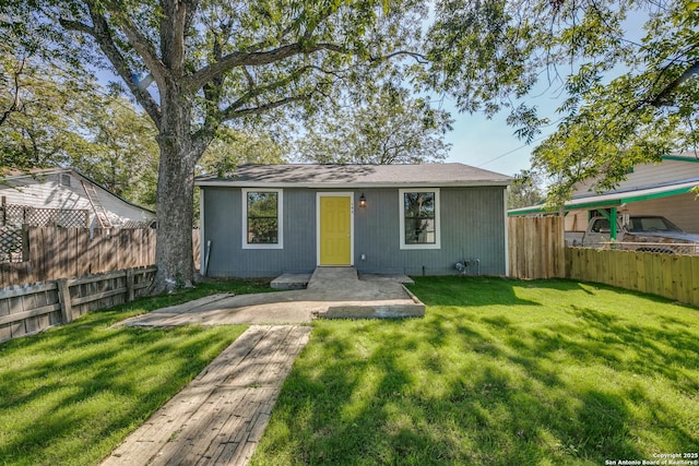 exterior space featuring an outbuilding, a fenced backyard, and a front lawn