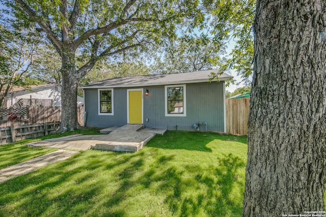 view of front of home featuring fence private yard, a front yard, and a patio