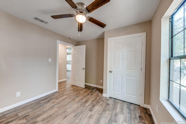 unfurnished bedroom featuring light wood-style floors, baseboards, and visible vents