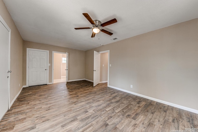 unfurnished bedroom with a ceiling fan, light wood-type flooring, visible vents, and baseboards