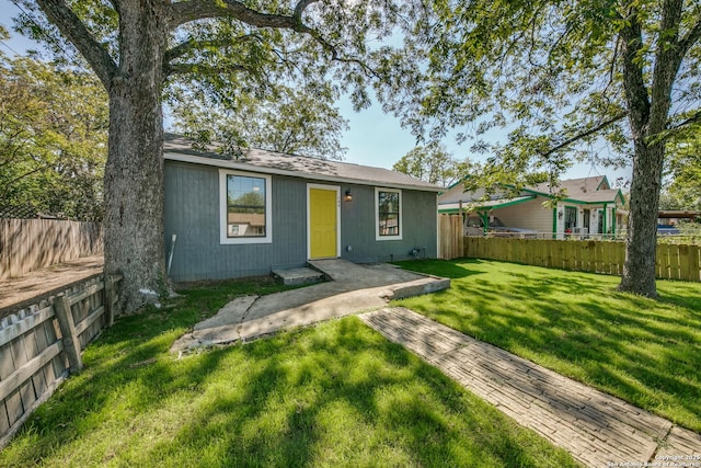 view of front of house with a front yard, a patio area, and a fenced backyard