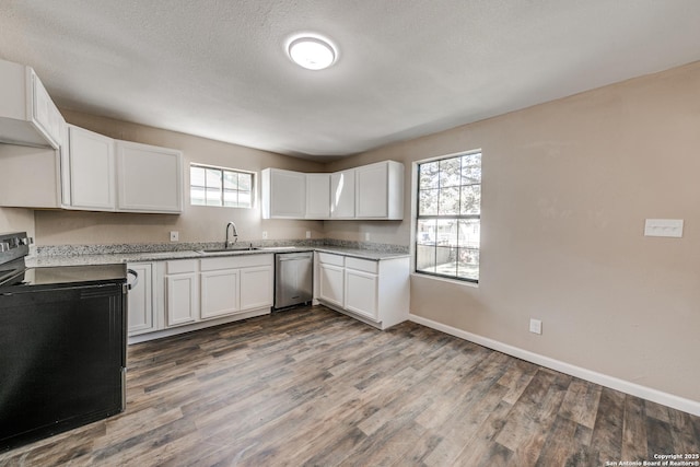 kitchen with light countertops, white cabinets, a sink, and electric range