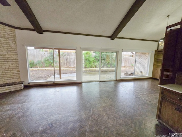 unfurnished living room featuring dark parquet flooring, a wealth of natural light, and a textured ceiling