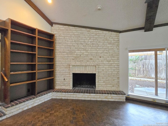 unfurnished living room with parquet floors, lofted ceiling with beams, a textured ceiling, and a brick fireplace