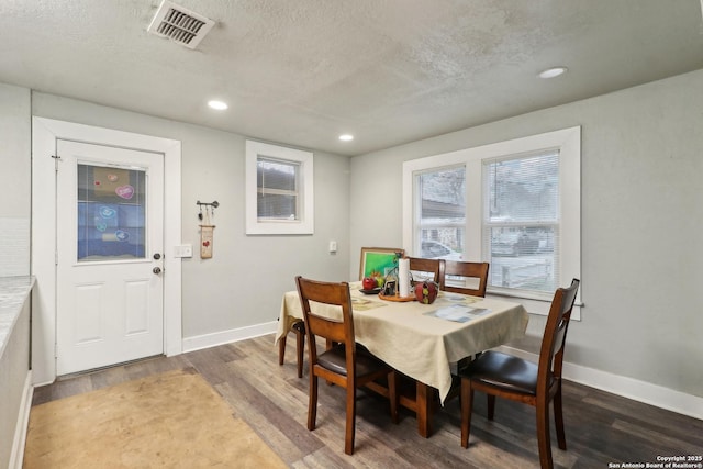 dining area with dark hardwood / wood-style floors and a textured ceiling