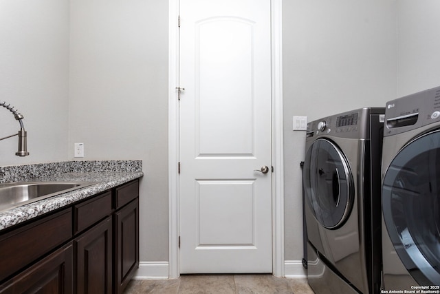 washroom with cabinets, separate washer and dryer, and sink