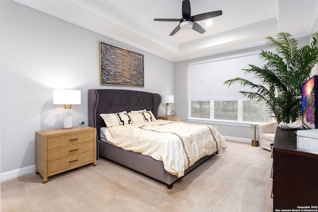 carpeted bedroom with ornamental molding, a raised ceiling, and ceiling fan