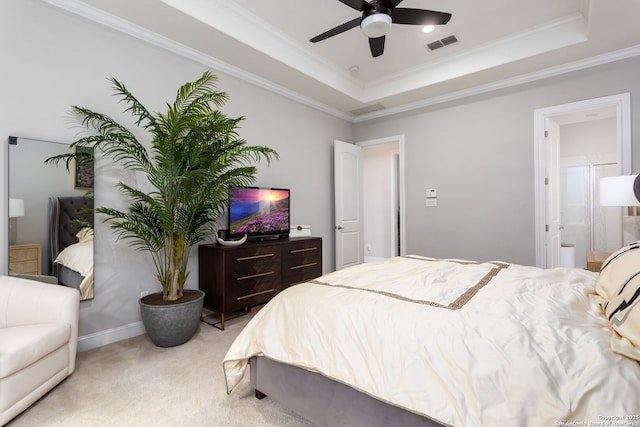 carpeted bedroom featuring crown molding, connected bathroom, and a raised ceiling