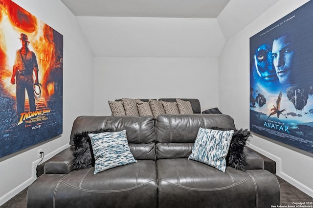 home theater room with vaulted ceiling and carpet flooring