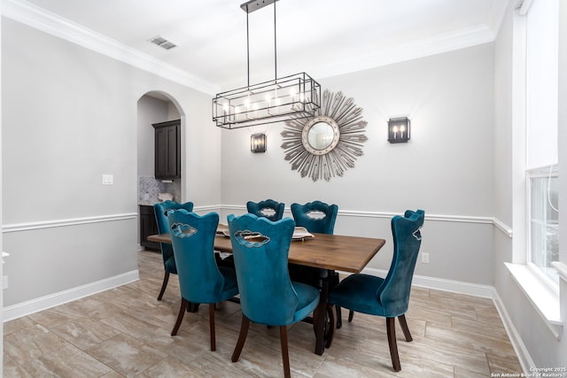 dining area with an inviting chandelier and ornamental molding