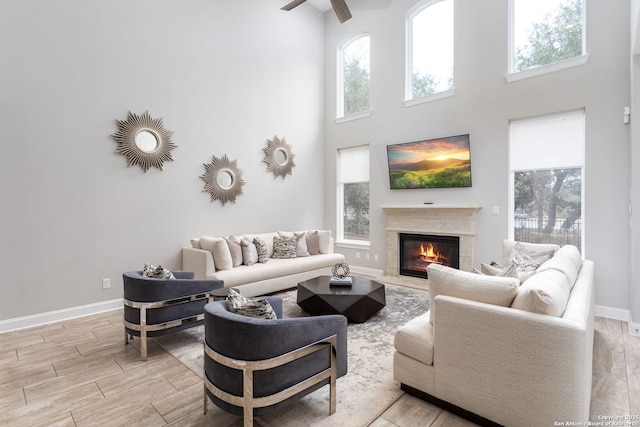 living room featuring a towering ceiling, a wealth of natural light, and ceiling fan