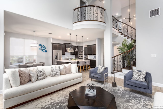 living room featuring an inviting chandelier and a towering ceiling