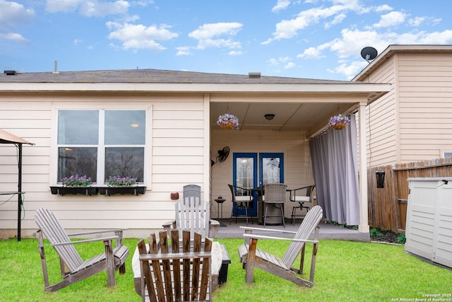 back of property with a yard and a patio area