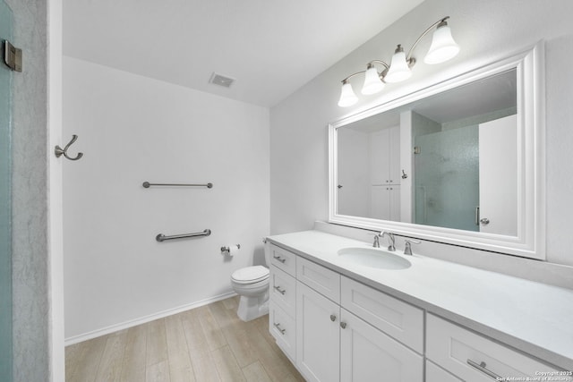 bathroom featuring vanity, hardwood / wood-style floors, toilet, and an enclosed shower