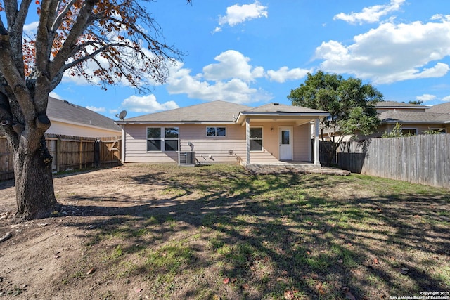 rear view of property featuring a lawn, a patio, and central air condition unit