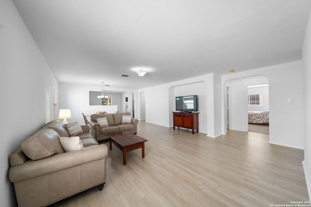 living room with an inviting chandelier and light hardwood / wood-style floors