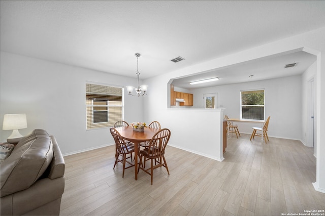 dining room with an inviting chandelier and light wood-type flooring