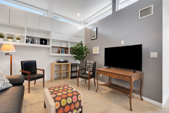 living room with light carpet and a towering ceiling