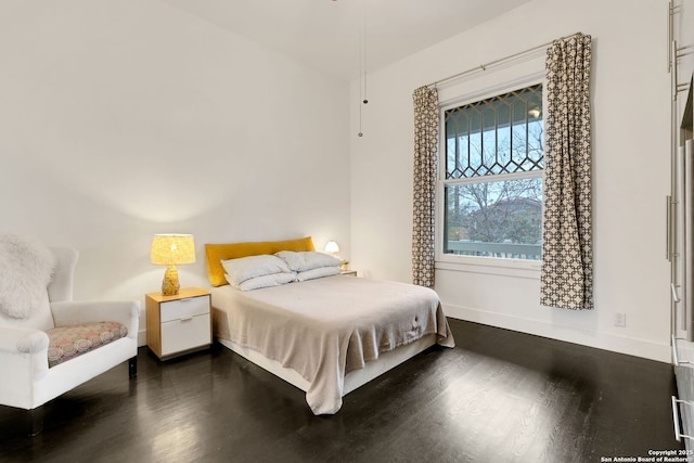 bedroom with dark hardwood / wood-style flooring