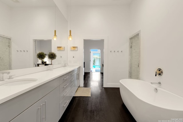 bathroom featuring hardwood / wood-style flooring, vanity, separate shower and tub, and a high ceiling