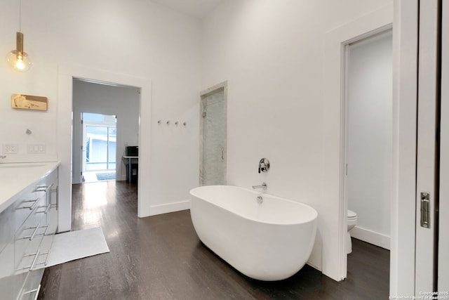 full bathroom with hardwood / wood-style flooring, vanity, toilet, and separate shower and tub