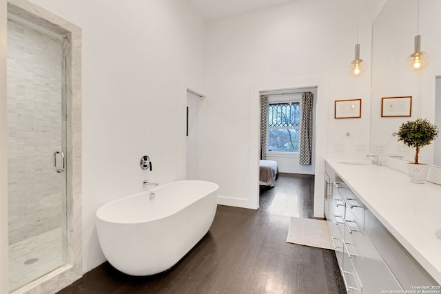 bathroom with hardwood / wood-style flooring, vanity, and separate shower and tub