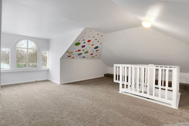 bonus room with vaulted ceiling and carpet