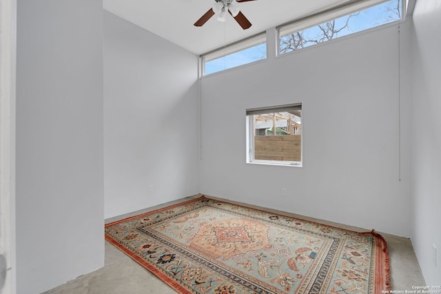 spare room featuring ceiling fan and a high ceiling